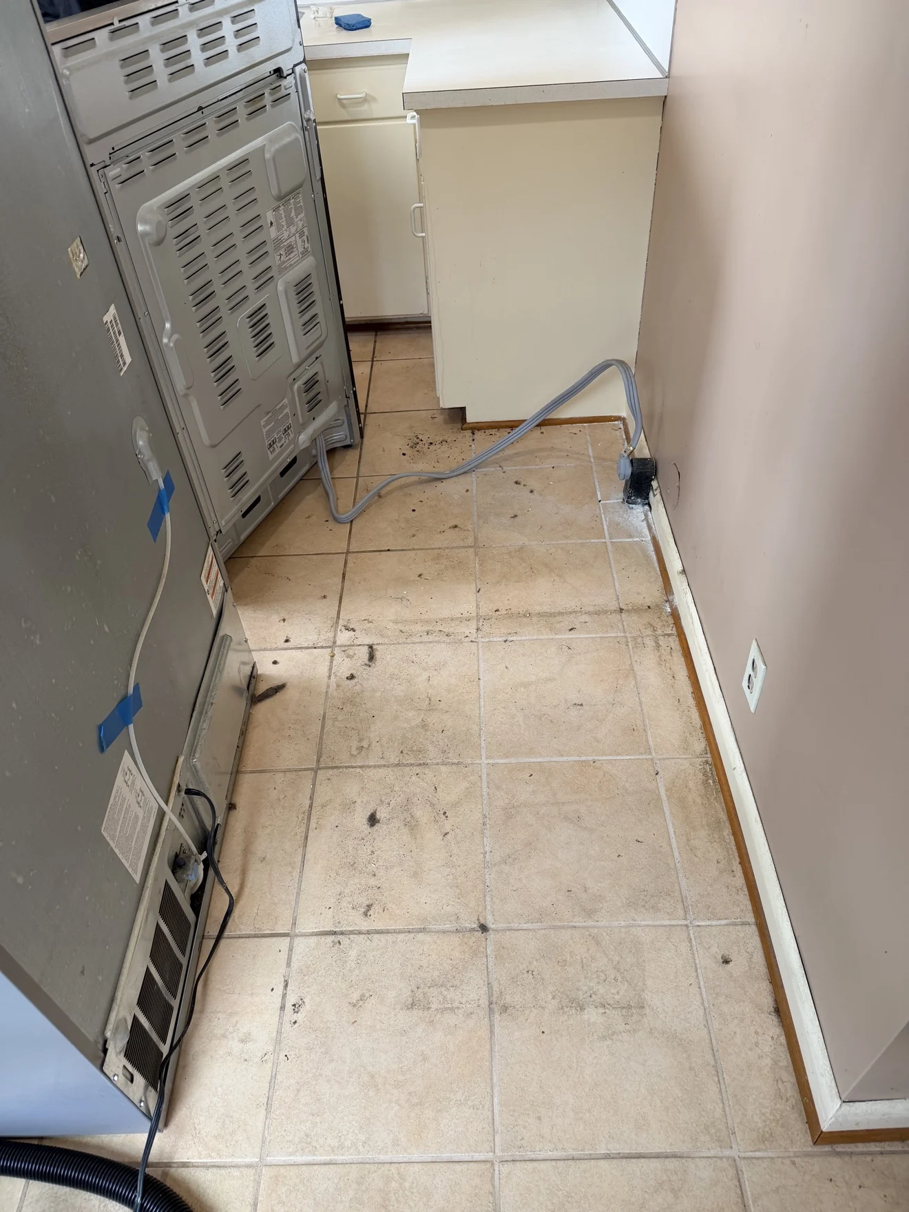 Floor behind refrigerator before cleaning